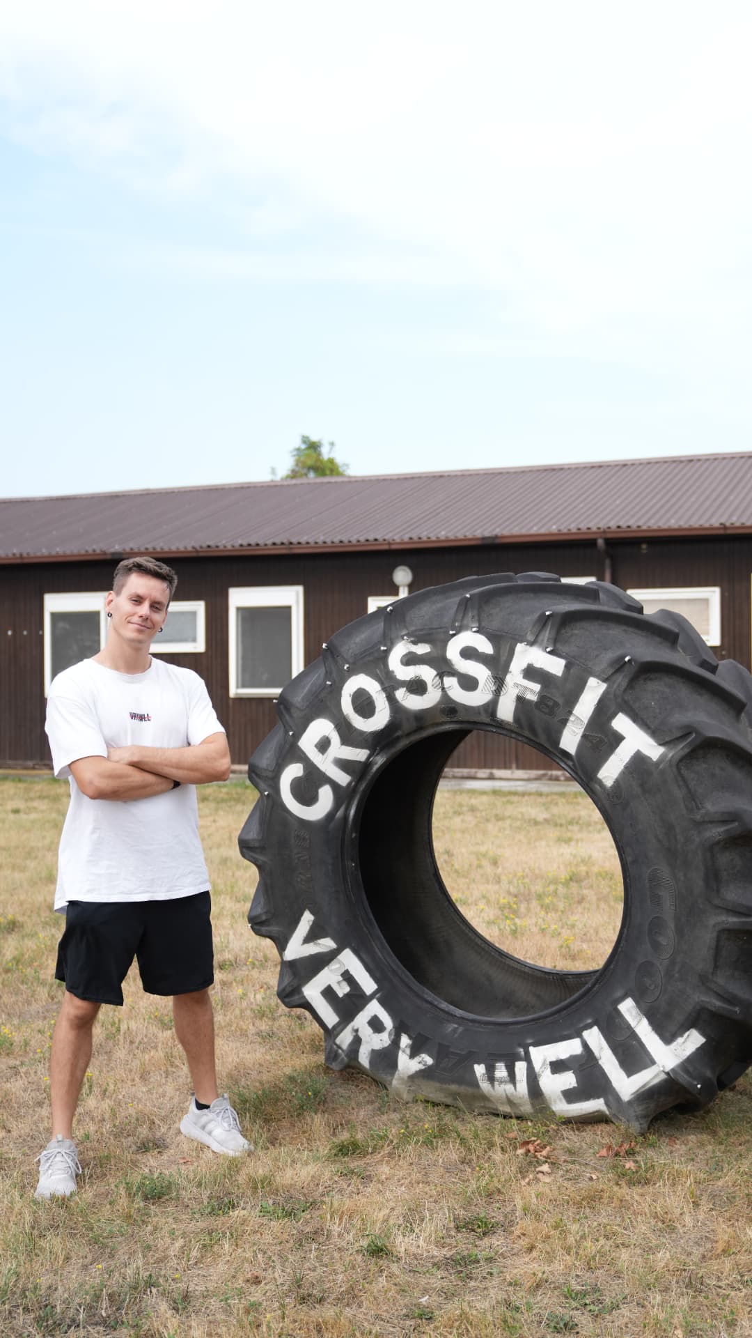 Coach accanto al tire CrossFit Very Well nel prato esterno